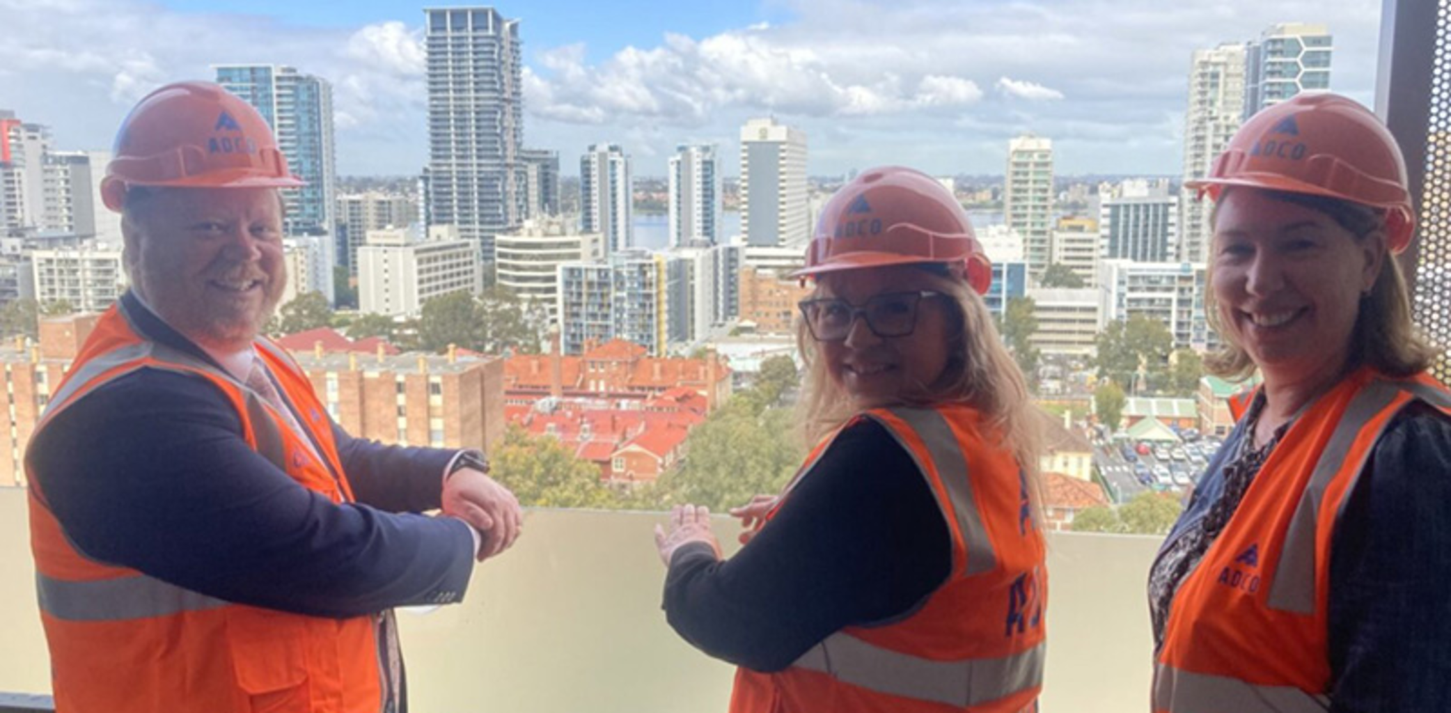 Three people standing in front of East Perth Common Ground construction site, including Homelessness Minister and Mission Australia leaders.