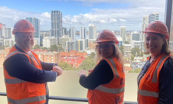 Three people standing in front of East Perth Common Ground construction site, including Homelessness Minister and Mission Australia leaders.