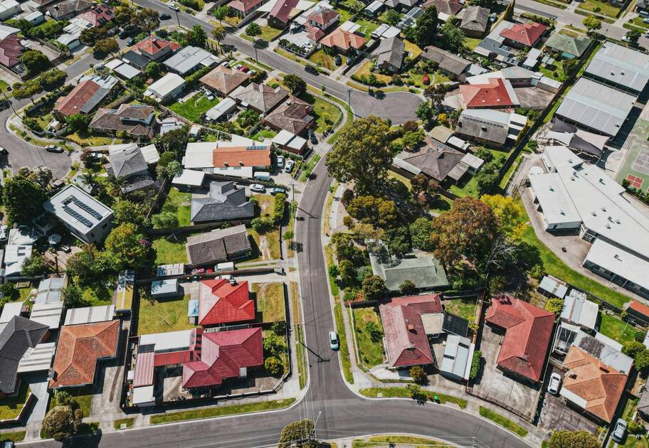 Aerial view of a suburban neighbourhood with houses, roads and green areas