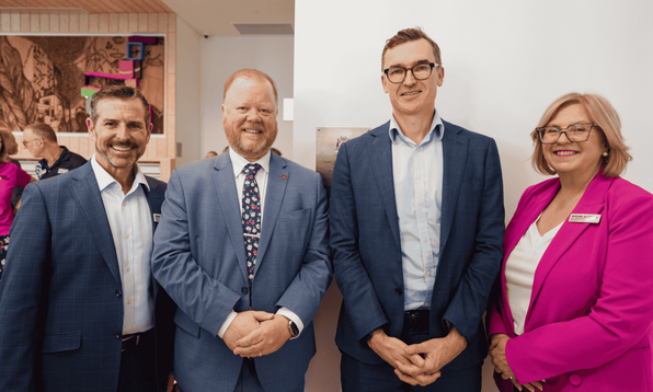 Mission Australia Deputy CEO, Ben Carblis and WA State Director stand side by side with WA government ministers smiling, during Common Ground East Perth opening event. 
